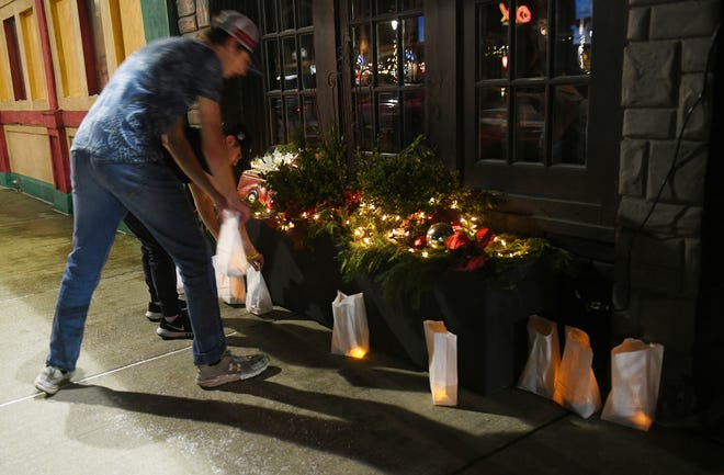 Jeremy Schwarb, 16, rear, of Oxford and Noah Wehner, 15, front, of Lake Orion put luminaries in front of the Oxford Tap House in Oxford, Mich. on Nov. 30, 2022.  Luminaries are lit and on display in Oxford in memory of the four students killed one year ago at Oxford High School.