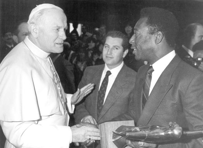 In this March 18, 1987 file photo, Pope John Paul II shakes hands with Brazil's former soccer player Pele during a private audience at the Vatican.
