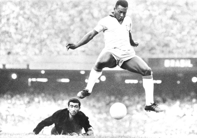 In this Aug. 1969 file photo, Brazil's Pele scores past Venezuela's goal keeper Fabrizio Fasano in Rio de Janeiro, Brazil.