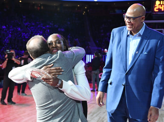 Kimberly Lanier, (daughter of Bob Lanier), hugs Arn Tellem, vice chairman of the Detroit Pistons, during the ceremony to honor Bob Lanier, former Piston James Edwards looks on.
