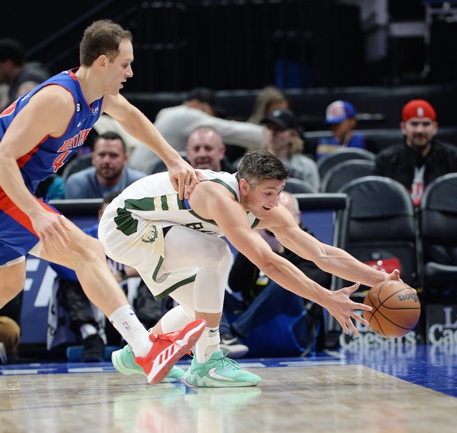 Milwaukee Bucks guard Grayson Allen (12) saves the ball from going out of bounds while being defended by Detroit Pistons forward Bojan Bogdanovic (44) in the first quarter.
