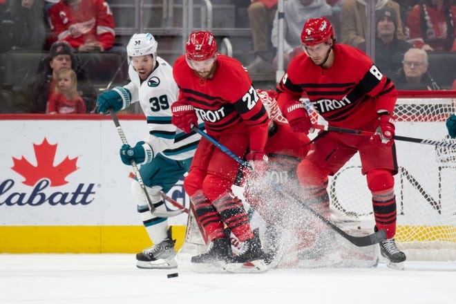 (From left) San Jose center Logan Couture, Detroit center Michael Rasmussen, and defenseman Ben Chiarot battle for the puck in front of Detroit’s net during the first period.