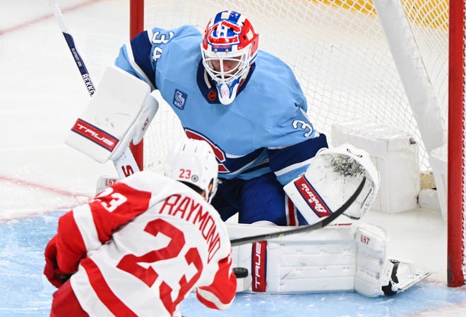Detroit Red Wings' Lucas Raymond attempts a shot against Montreal Canadiens goaltender Jake Allen.