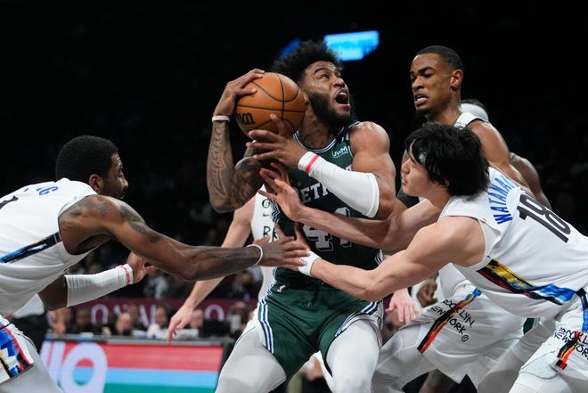 Detroit Pistons' Saddiq Bey, center, protects the ball from Brooklyn Nets' Kyrie Irving, left, Nic Claxton, second from right, Yuta Watanabe, right, during the second half of an NBA basketball game Thursday, Jan. 26, 2023 in New York. The Pistons won 130-122.