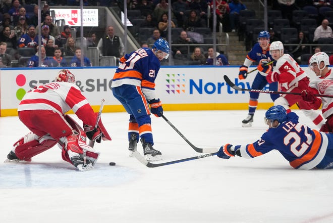 New York Islanders' Anders Lee (27) shoots the puck past Detroit Red Wings goaltender Magnus Hellberg (45) for a goal as teammate Kyle Palmieri (21) watches during the second period.