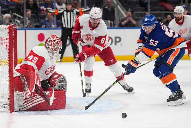 Detroit Red Wings goaltender Magnus Hellberg (45) protects his net from New York Islanders' Casey Cizikas (53) as teammate Ben Chiarot (8) watches during the second period.