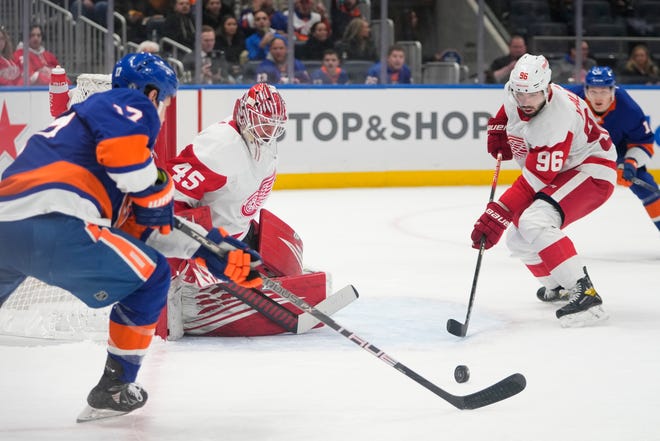 Detroit Red Wings goaltender Magnus Hellberg (45) and Jake Walman (96) protect their net from New York Islanders' Matt Martin (17) during the second period.
