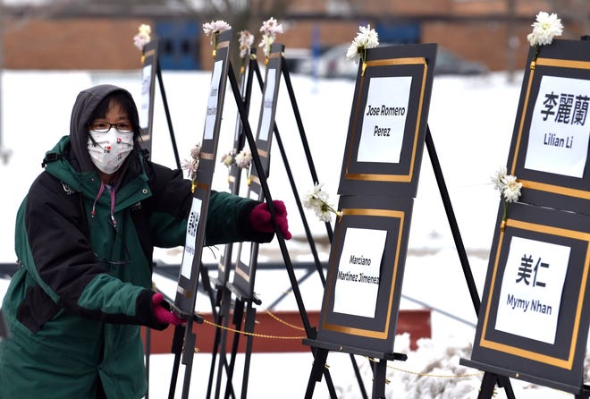 Peggy Chiu of Rochester Hills, a member of the Michigan Taiwanese American Organization, helps assemble poster boards with names of the victims who died in the California mass shootings Saturday, January 28, 2023, at Madison City Hall.