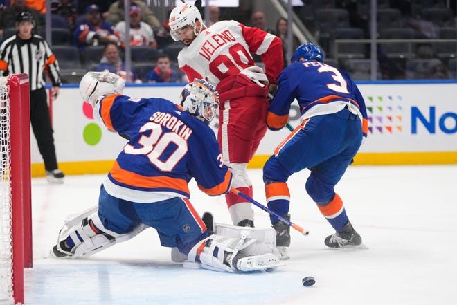 New York Islanders' Ilya Sorokin (30) stops a shot on goal by Detroit Red Wings' Joe Veleno (90) as treammate Adam Pelech (3) defends during the first period on Jan. 27, 2023, in Elmont, N.Y.