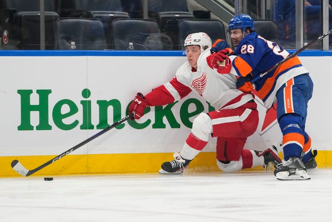 New York Islanders' Alexander Romanov (28) fights for control of the puck with Detroit Red Wings' David Perron (57) during the third period.