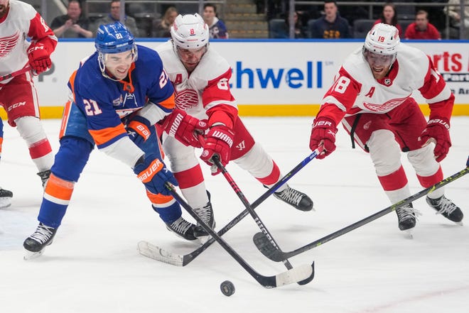 New York Islanders' Kyle Palmieri (21) fights for control of the puck with Detroit Red Wings' Ben Chiarot (8) and Andrew Copp (18) during the second period.
