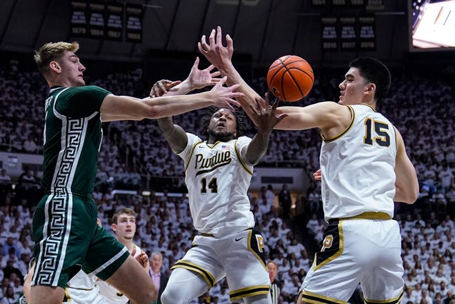Michigan State center Carson Cooper (15) fights for a rebound with Purdue guard David Jenkins Jr. (14) and center Zach Edey (15) during the first half.