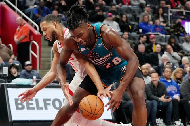 Houston Rockets guard Eric Gordon and Detroit Pistons center Isaiah Stewart (28) reach for the loose ball during the first half.