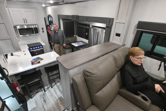 Donna Myer enjoys the comfort of the Keystone Montana High Coutry 377FL multi-leveled RV with the kitchen in the background.