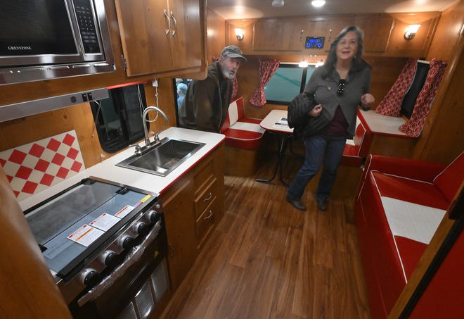 Doug Hefner and Ann Hefner look over a retro styled wood like paneling and flooring on the Gulf Stream Vintage-23RSS.