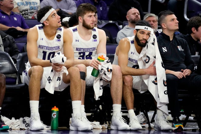 Northwestern forward Tydus Verhoeven, left, center Matthew Nicholson, center, and guard Boo Buie react as they watch teammates during the second half of an NCAA college basketball game against Michigan in Evanston, Ill., Thursday, Feb. 2, 2023.