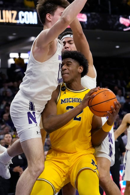Michigan forward Tarris Reed Jr., right, drives as Northwestern guard Brooks Barnhizer, left, and forward Tydus Verhoeven guard during the first half of an NCAA college basketball game in Evanston, Ill., Thursday, Feb. 2, 2023.