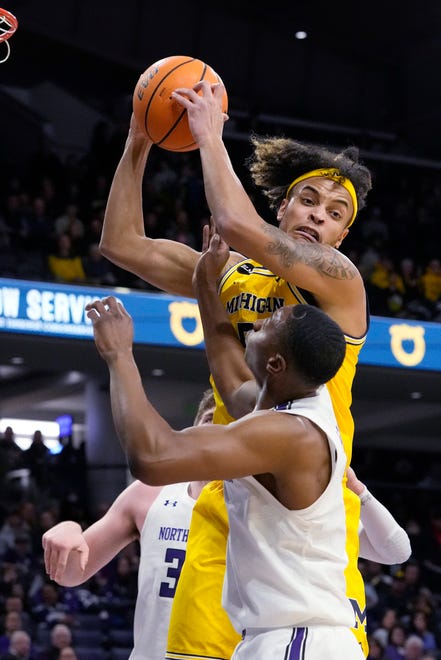 Michigan forward Terrance Williams II, top, rebounds the ball against Northwestern center Matthew Nicholson, left, and guard Chase Audige during the first half of an NCAA college basketball game in Evanston, Ill., Thursday, Feb. 2, 2023.
