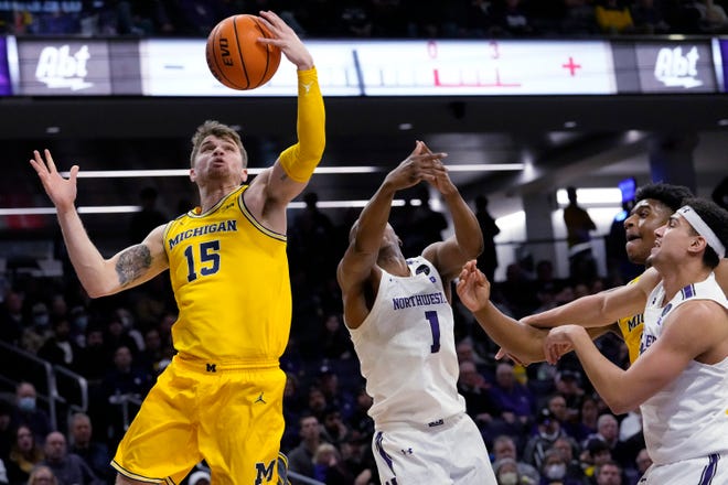 Michigan guard Joey Baker (15) rebounds the ball against Northwestern guard Chase Audige (1) and forward Tydus Verhoeven, front right, during the first half of an NCAA college basketball game in Evanston, Ill., Thursday, Feb. 2, 2023.