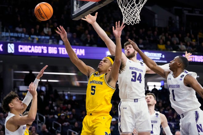 Michigan forward Terrance Williams II. (5) battles for a rebound against Northwestern guard Ty Berry, left, center Matthew Nicholson (34) and guard Chase Audige (1) during the first half of an NCAA college basketball game in Evanston, Ill., Thursday, Feb. 2, 2023.