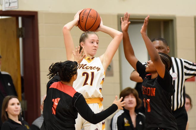 Farmington Hills Mercy’s Aizlyn Albanese, middle, is double teamed by Detroit Edison guard Devin Hagemann, left, and forward NaBrea Lane in the fourth quarter, Friday, Feb. 3, 2023, at Mercy HS in Farmington Hills, Mich.
