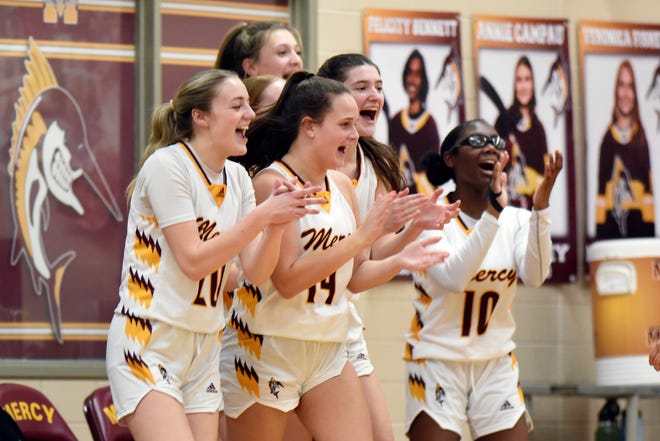The Farmington Hills Mercy girls basketball team cheer on their teammtes after a timeout was called by Detroit Edison in the first quarter, Friday, Feb. 3, 2023, at Mercy HS in Farmington Hills, Mich.