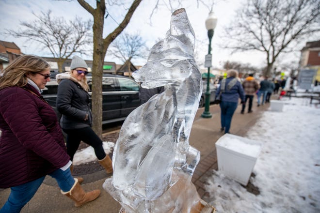 Visitors walk past rows of ice carvings during the Plymouth Ice Festival, in Plymouth, February 5, 2023.