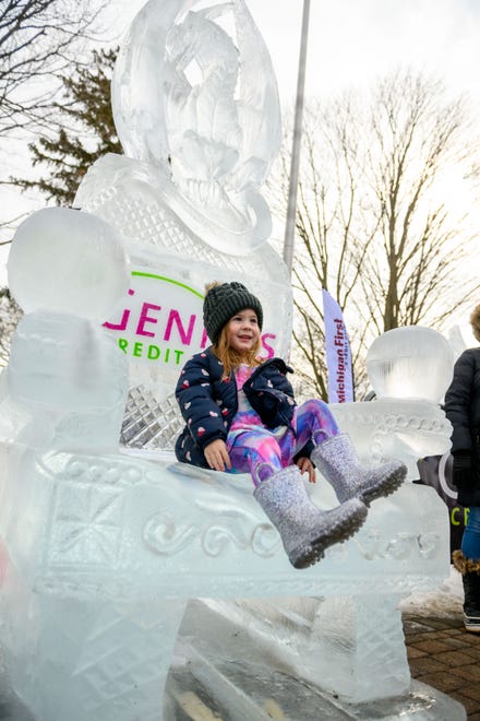 Three-year-old Holly Luurtsema, of Livonia, sits on a throne made of ice while visiting the Plymouth Ice Festival, in Plymouth, February 5, 2023.