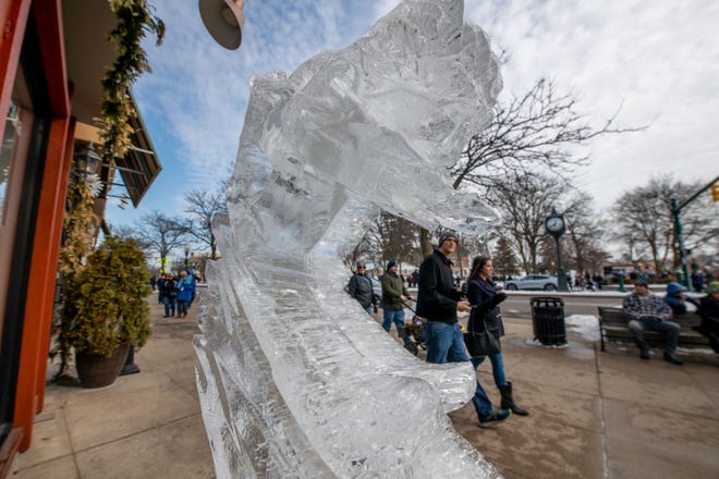 Visitors walk past the rows of ice carvings during the Plymouth Ice Festival, in Plymouth, February 5, 2023.