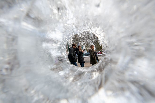 Visitors walk past the rows of ice carvings during the Plymouth Ice Festival in Plymouth, February 5, 2023.