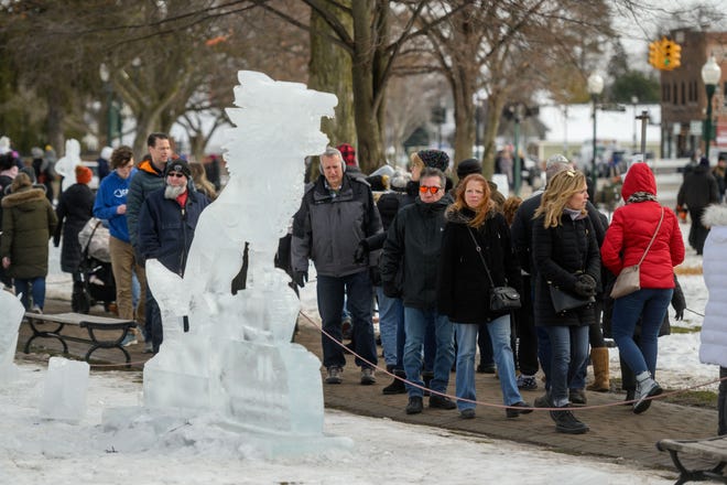 Throngs of visitors walk past rows of ice sculptures during the Plymouth Ice Festival in Plymouth, February 5, 2023.