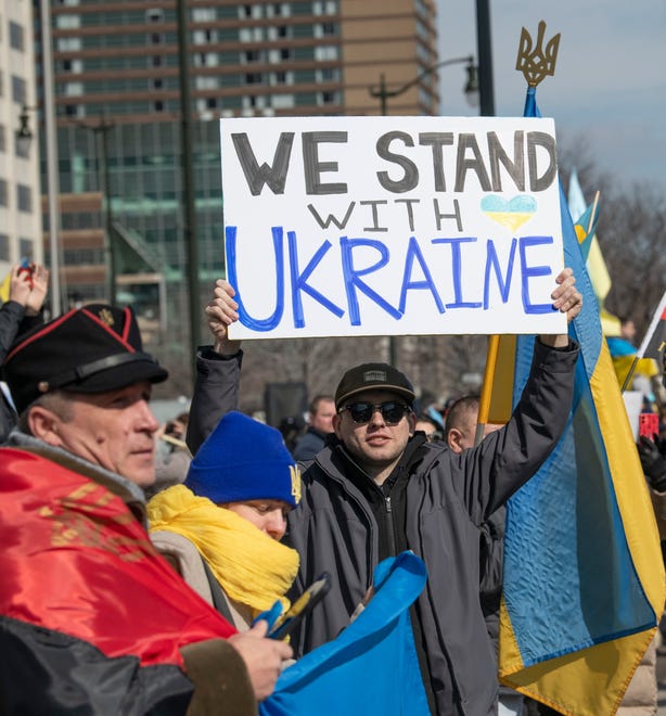 Sergiy Kuzenkov, 23, holds a “We Stand with Ukraine” sign as he takes part in the ‘Stand With Ukraine’ rally in downtown Detroit. Kuzenkov was born in the Crimea region of Ukraine, but has lived in the U.S. since he was six years old. He now lives in Warren.