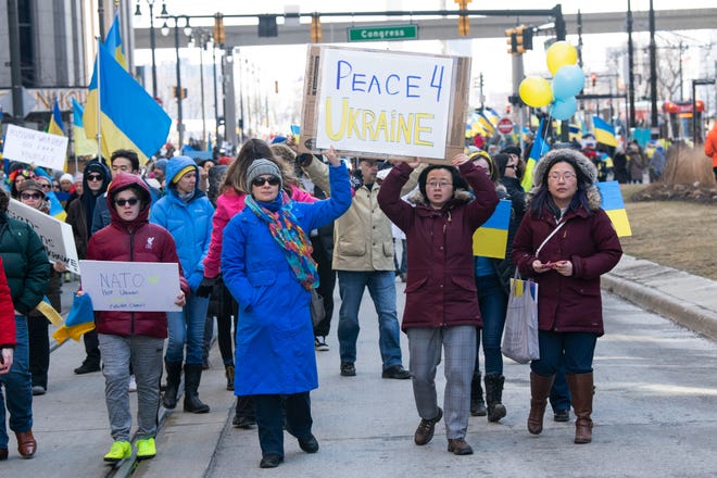ÔStand With UkraineÕ marchers carry signs in downtown Detroit during a rally in support of the Ukrainian people after Russian President Vladimir Putin ordered troops to invade the neighboring country. The event was organized by the Ukrainian-American Crisis Response Committee of Michigan.
